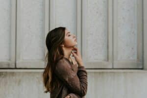 profile of woman in brown long-sleeved top face turned up to the sky